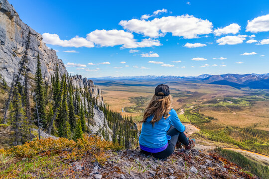 Woman hiking along the Dempster Highway enjoying the scenery on top of Sapper Hill; Yukon, Canada