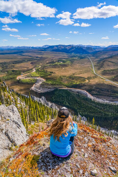 Woman hiking along the Dempster Highway enjoying the scenery on top of Sapper Hill; Yukon, Canada