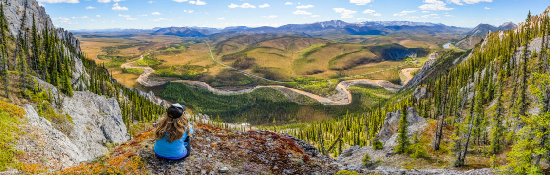Woman hiking along the Dempster Highway enjoying the scenery on top of Sapper Hill; Yukon, Canada
