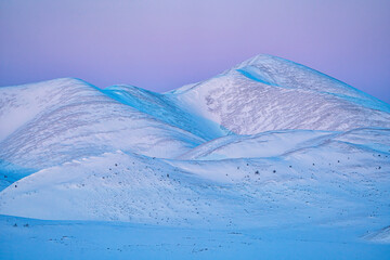 Sunset light on the snow covered mountains of the Richardson Range near the Arctic Circle; Yukon Canada