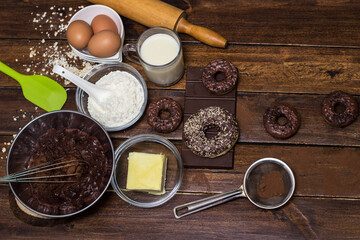 Preparing doughnuts at home. Ingredients for donuts such as eggs, milk, chocolate, pudding, butter, cacao, flour, rolling pin, cake pan, grater, egg beater, spatula