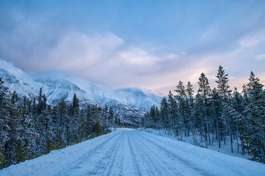 Sunrise over the snow-covered mountains of the Gray Ridge along the Annie Lake Road in early morning light in winter; Whitehorse, Yukon, Canada