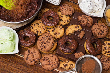 A sweet table containing ice cream, donuts and chocolate chip cookies