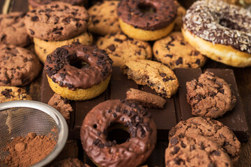 A sweet table containing ice cream, donuts and chocolate chip cookies