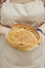 Female hands holding bread.