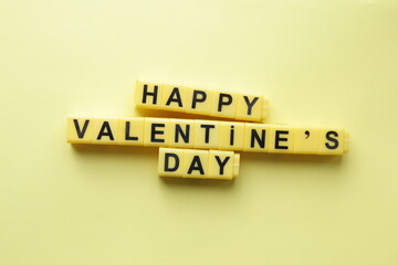 Happy Valentine's Day. An inscription made from yellow cubes. Creative concept.