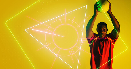 African american player with arms raised throwing rugby ball over illuminated geometric shapes