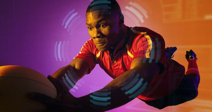 African american rugby player jumping and catching ball over circular pattern, copy space - Powered by Adobe