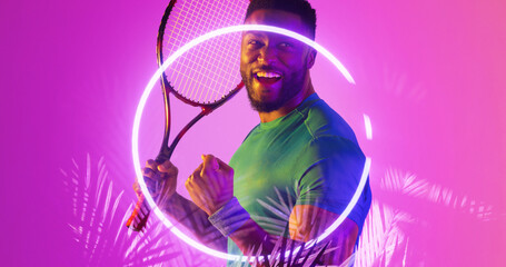 Happy african american tennis player holding racket by illuminated plants and circle, copy space