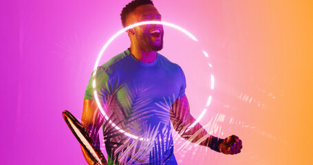 African american male player with racket screaming by illuminated plants and circle
