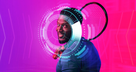 Smiling african american male tennis player with racket holding illuminated circular pattern