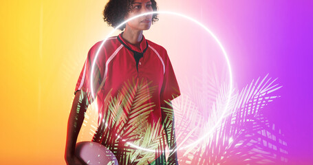 Illuminated circle and plants over biracial female rugby player holding ball on gradient background