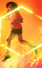 Illuminated hexagon and plants over biracial female player with ball jumping on orange background