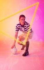 Caucasian female rugby player with ball crouching by illuminated triangle on gradient background