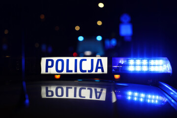 Radiowóz polska policja z Sygnalizator błyskowy niebieski na dachu radiowozu. Alarmowo wieczorem. - obrazy, fototapety, plakaty