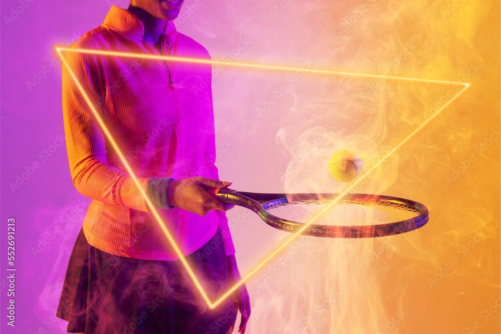 Poster midsection of african american female player playing with racket and ball by illuminated triangle