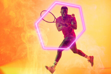 Illuminated hexagon over african american male player playing tennis with racket and ball