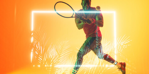 African american male player playing tennis with racket by illuminated rectangle and plants