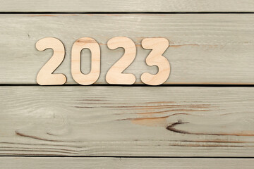 Happy New Year 2023. Symbol from number 2023 on wooden background