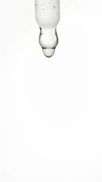 Cosmetic pipette with drops of face serum macro on a white background. Treatment, health, skincare