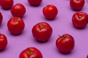 several acerolas on a lilac background