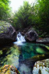 Obraz premium Long exposure of a little waterfall inside a stream in the Valsangone valley, Piedmont, Italy