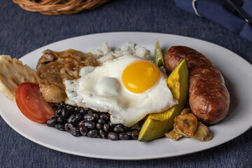 Bandeja paisa, typical food of Colombia in white plate.