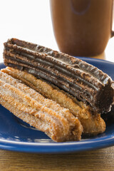 Close up of typical Argentine churros on blue dish.