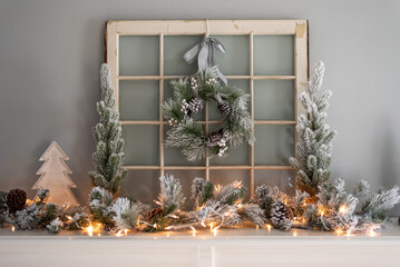 Holiday mantel decorated with flocked garland and wreath