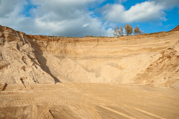 sand quarry, in the photo sand mountain in the quarry in the background blue sky and clouds bottom...