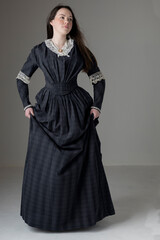 A young Victorian woman wearing a blue cotton dress with lace trim