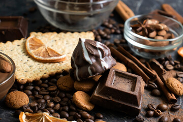Chocolate paste, nuts, cookies on a dark background