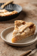 Slice of traditional apple pie with ice cream on brown textured background, menu, text space