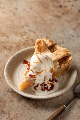 Slice of traditional apple pie with ice cream on brown textured background, menu, text space. Vertical