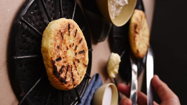 Hand taking an "Arepa" Clombian traditional food from a table 