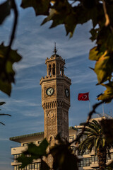 Clock tower sen through the leaves and sky. © Osman
