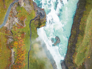 Naklejka premium Directly above the Gullfoss waterfall with foamy water falling down the rocks