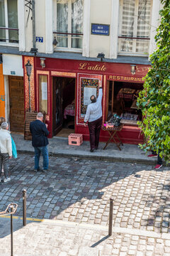 The front of a picturesque cafe in Montmartre being painted