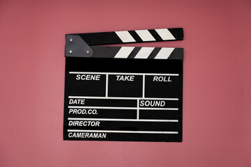 Fototapeta na wymiar movie clapper on red table background ; film, cinema and video photography concept