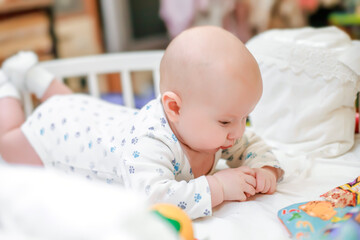 The tiny newborn saw his fingers. Development of fine motor skills of children. Children study their bodies. The baby sorts through the fingers on her hand.