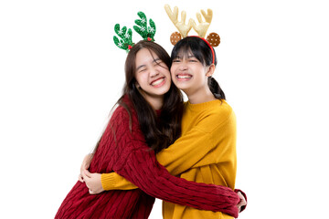 Happy cute Asian girls wear warm knitted sweater hugging together. Christmas celebration concept...