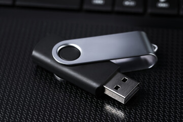 Modern usb flash drive on laptop, closeup
