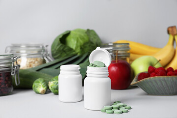 Bottles of prebiotic pills and food on grey table
