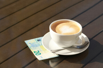 Tasty hot coffee and payment for order on table, space for text. Leave tip