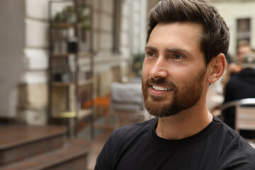 Portrait of handsome bearded man outdoors, space for text