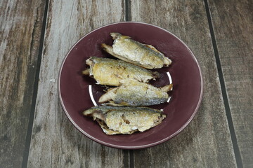 Pile of deep fried mackerel fish serving on the plate. Famous seafood menu in Asian restaurant.