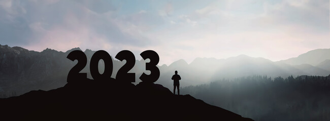 silhouette forming the new year 2023 on the top of the mountain