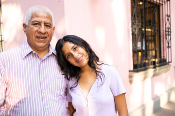 Portrait of grandfather and granddaughter standing in the street.