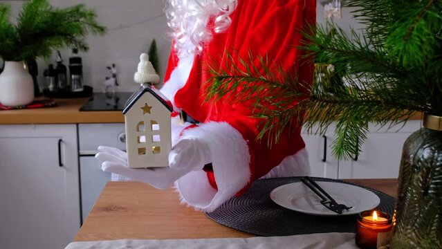 House key with keychain cottage in hands of Santa Claus outdoor in snow. Deal for real estate, purchase, construction, relocation, mortgage. Cozy home. Merry Christmas, new year booking event and hall