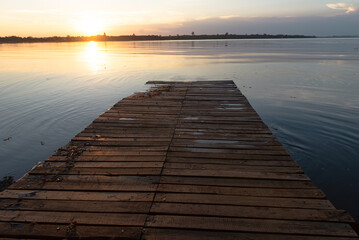 Fototapeta na wymiar Wooden pier at sunset on a lake in Bueng Kan, Thailand 2022 